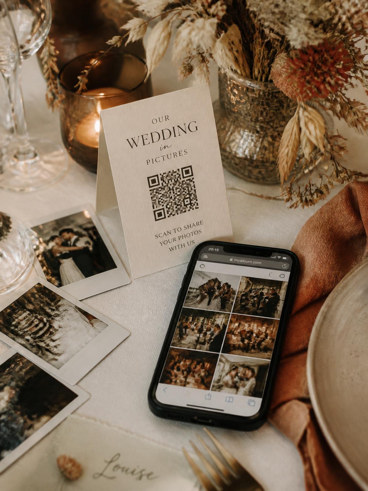Trouwtafel met QR-code kaartje en smartphone die een gedeelde fotogalerij toont